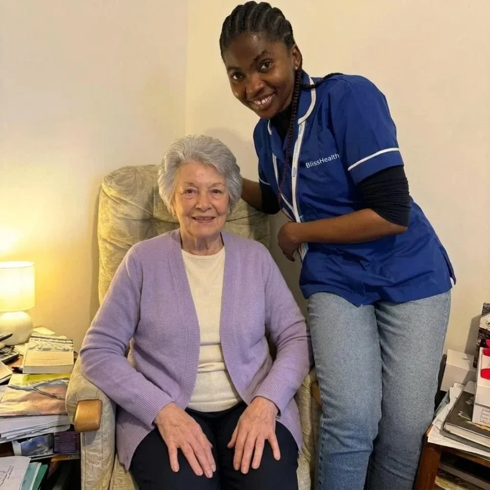 A BlissHealth carer in a branded blue uniform supporting a client
